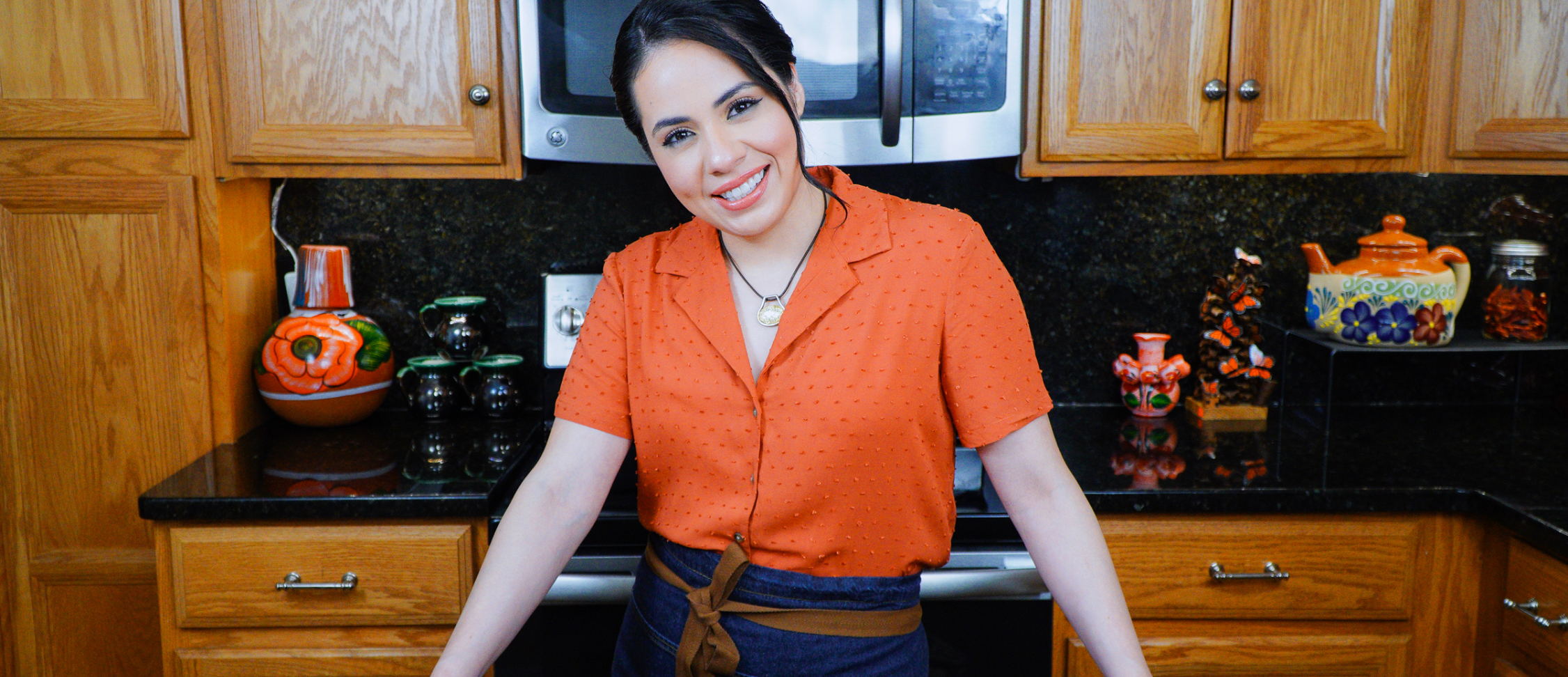 this is rossana smiling for the camera while in her kitchen.