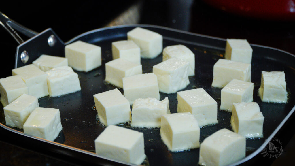 panela cheese being fried on a griddle 