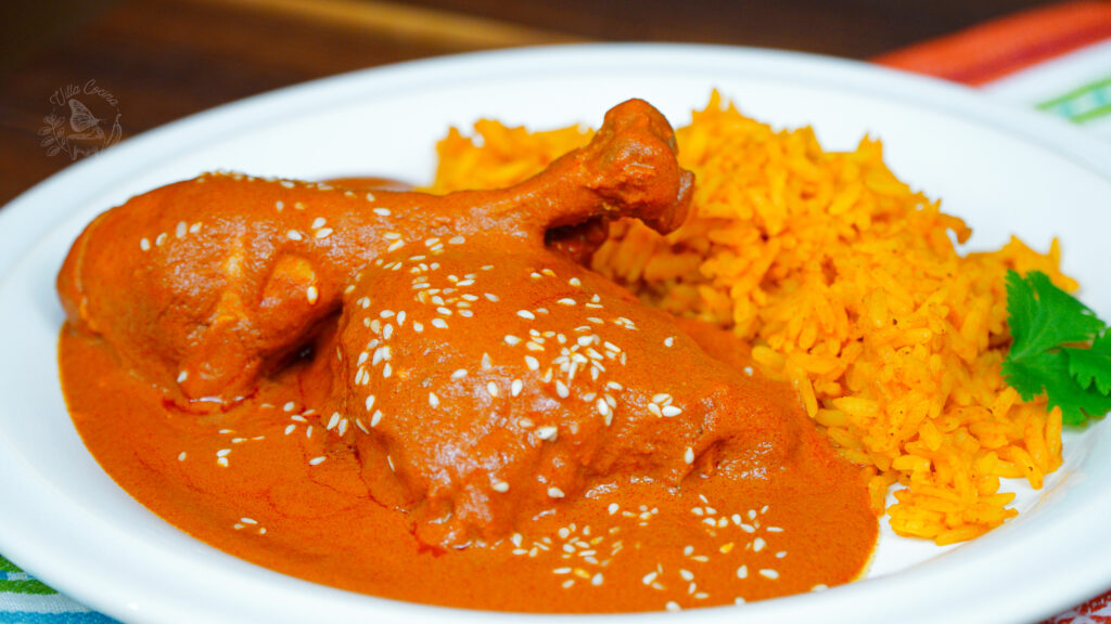 a plate with mole rojo and mexican rice