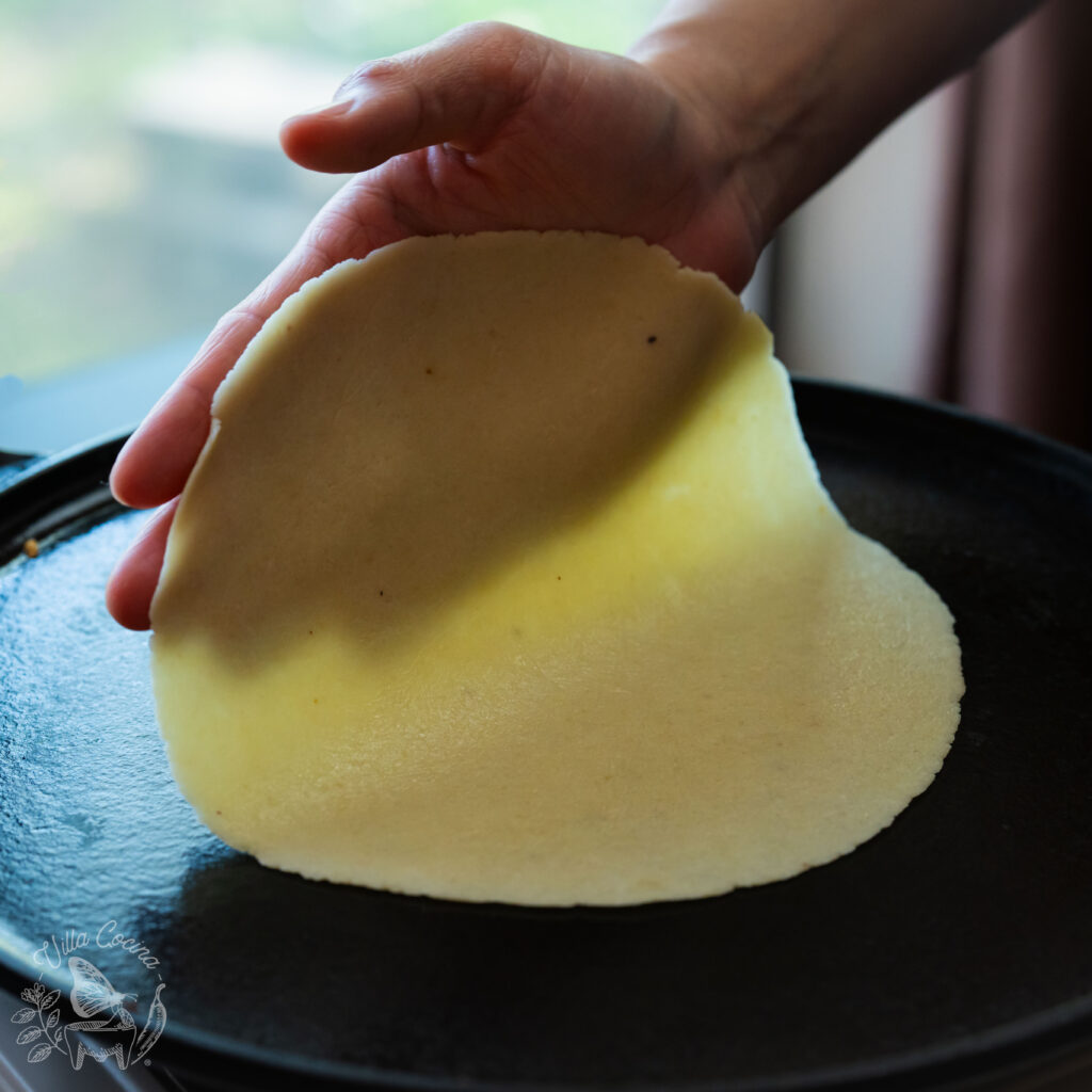 demonstration of the correct way to place a tortilla to cook. all done by hand.