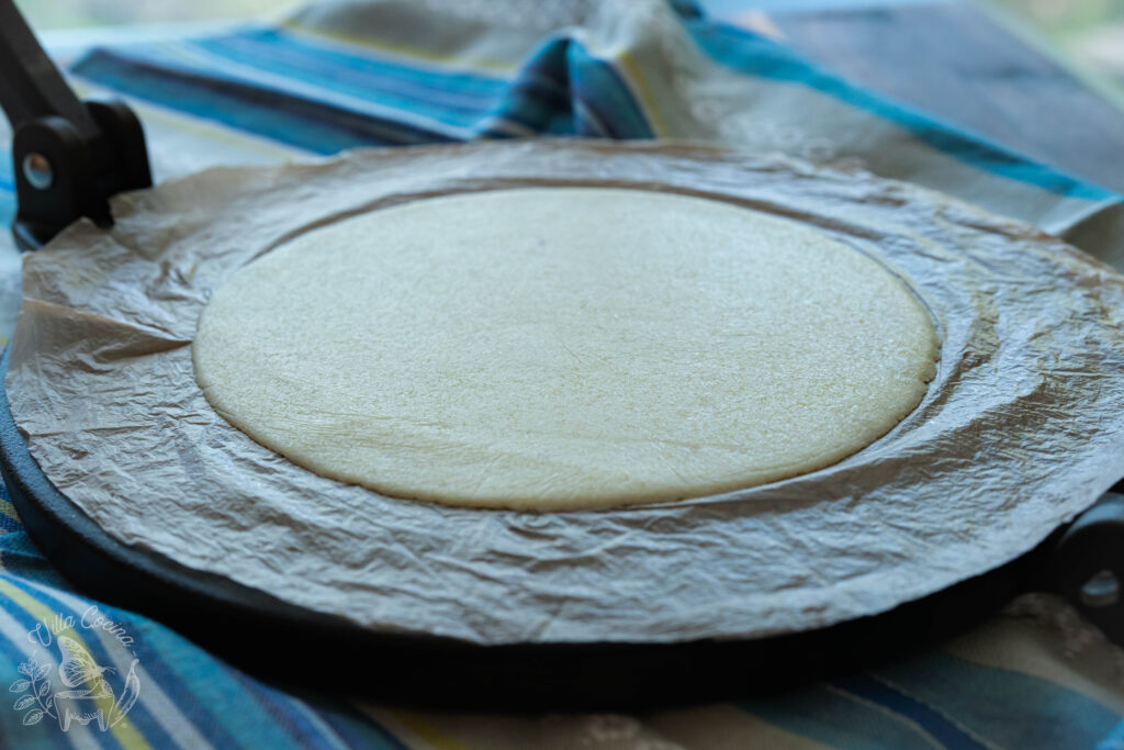 Flatten almond flour dough ready to be cooked on a griddle or comal.