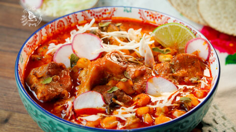 This is an Authentic Pozole Rojo. It is made with pork, Hominy, dried peppers for the sauce, spices, and your choice of toppings.