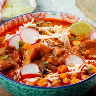 This is an Authentic Pozole Rojo. It is made with pork, Hominy, dried peppers for the sauce, spices, and your choice of toppings.