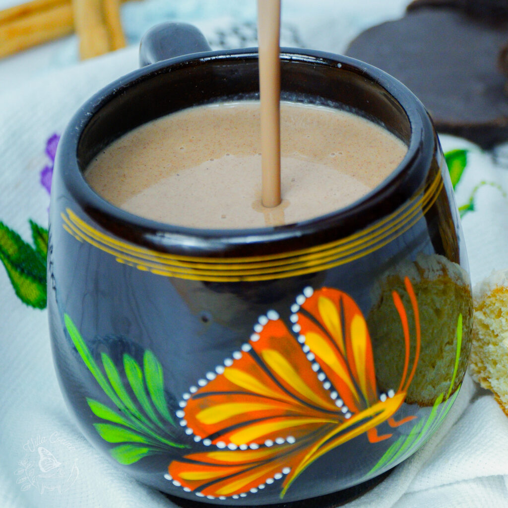 a stream of champurrado poured into a mug