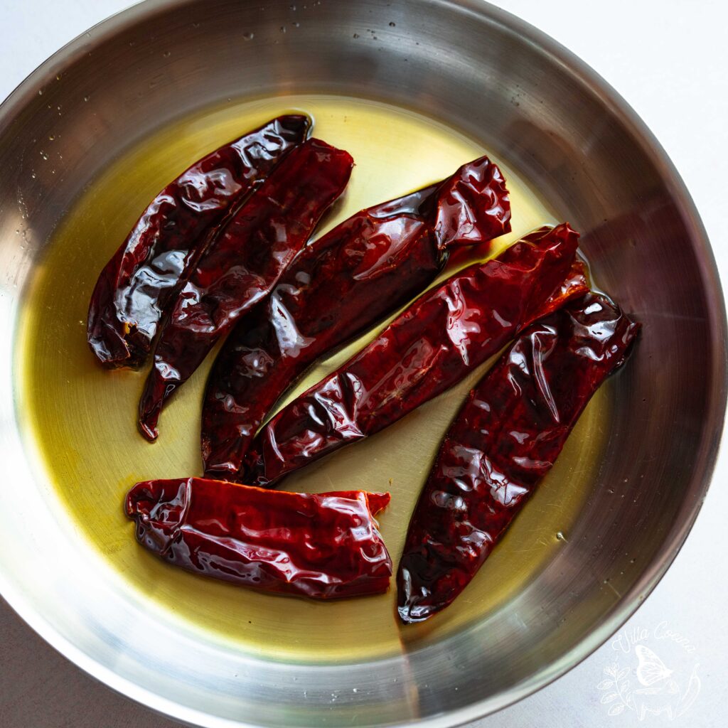 Guajillo peppers being toasted in avocado oil.