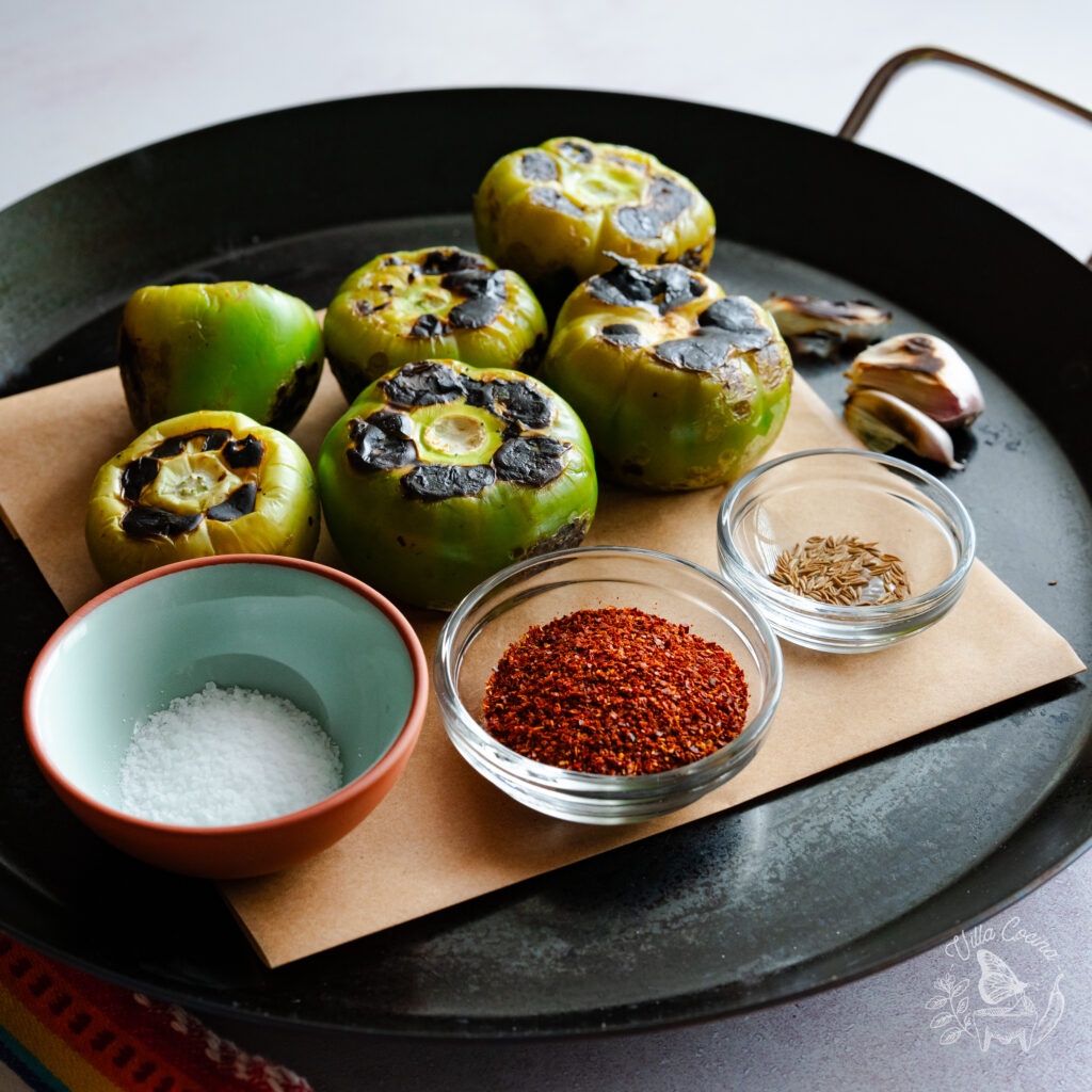 Roasted tomatillos, cumin, garlic, guagillo pepper powder, and salt ready to be made into a salsa