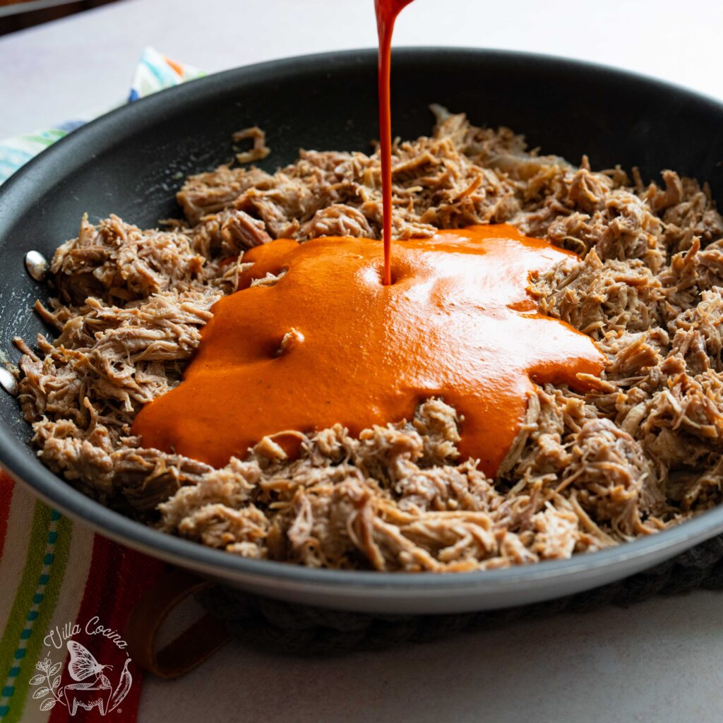 Pulled pork being covered with a chilli sauce