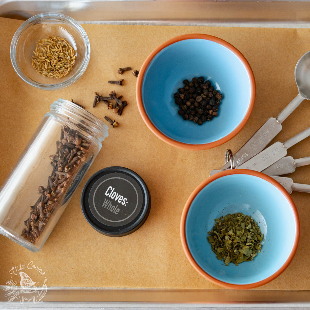 Spices being displayed: thyme, cloves, whole black pepper, oregano.