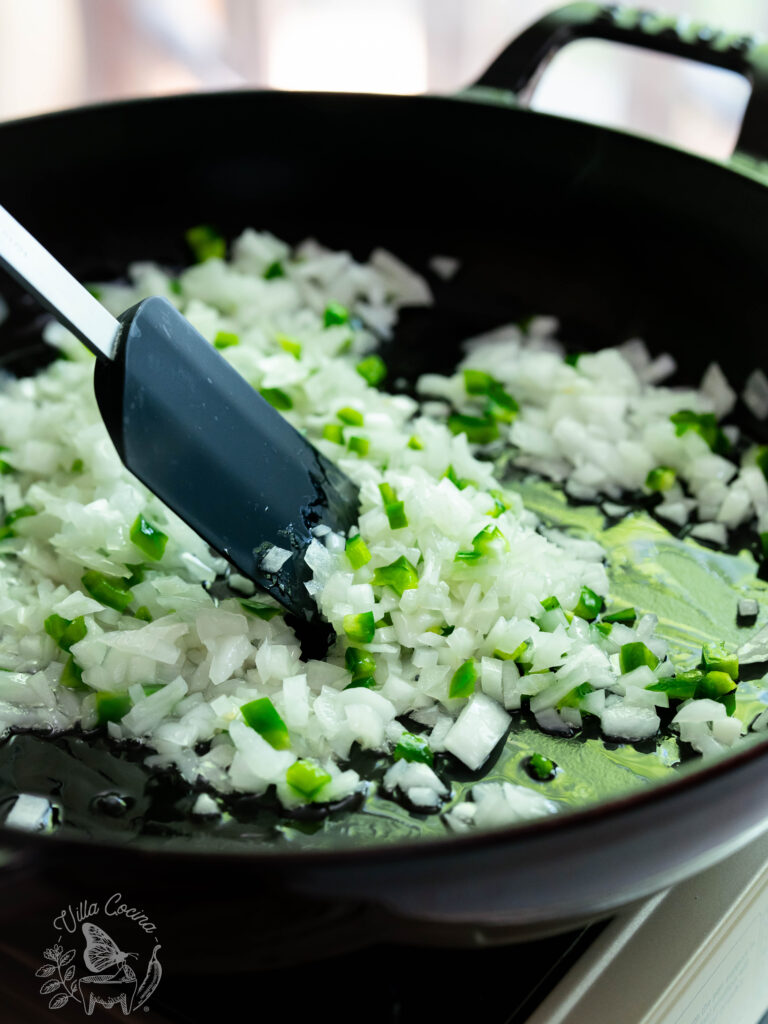 sautéing onion and jalapeño in a pan