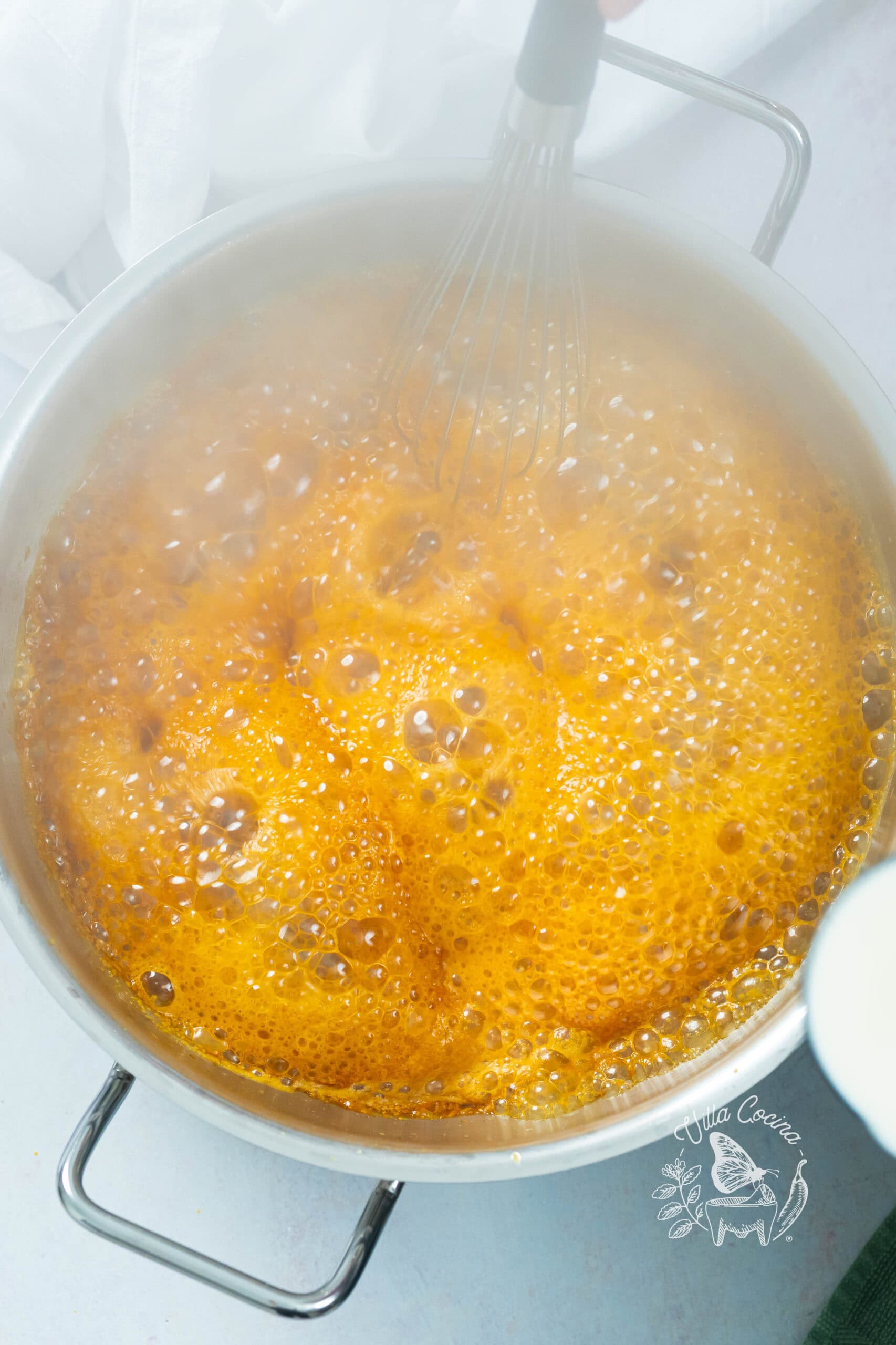 First addition of warm milk to caramel, bubbling vigorously during deglazing.