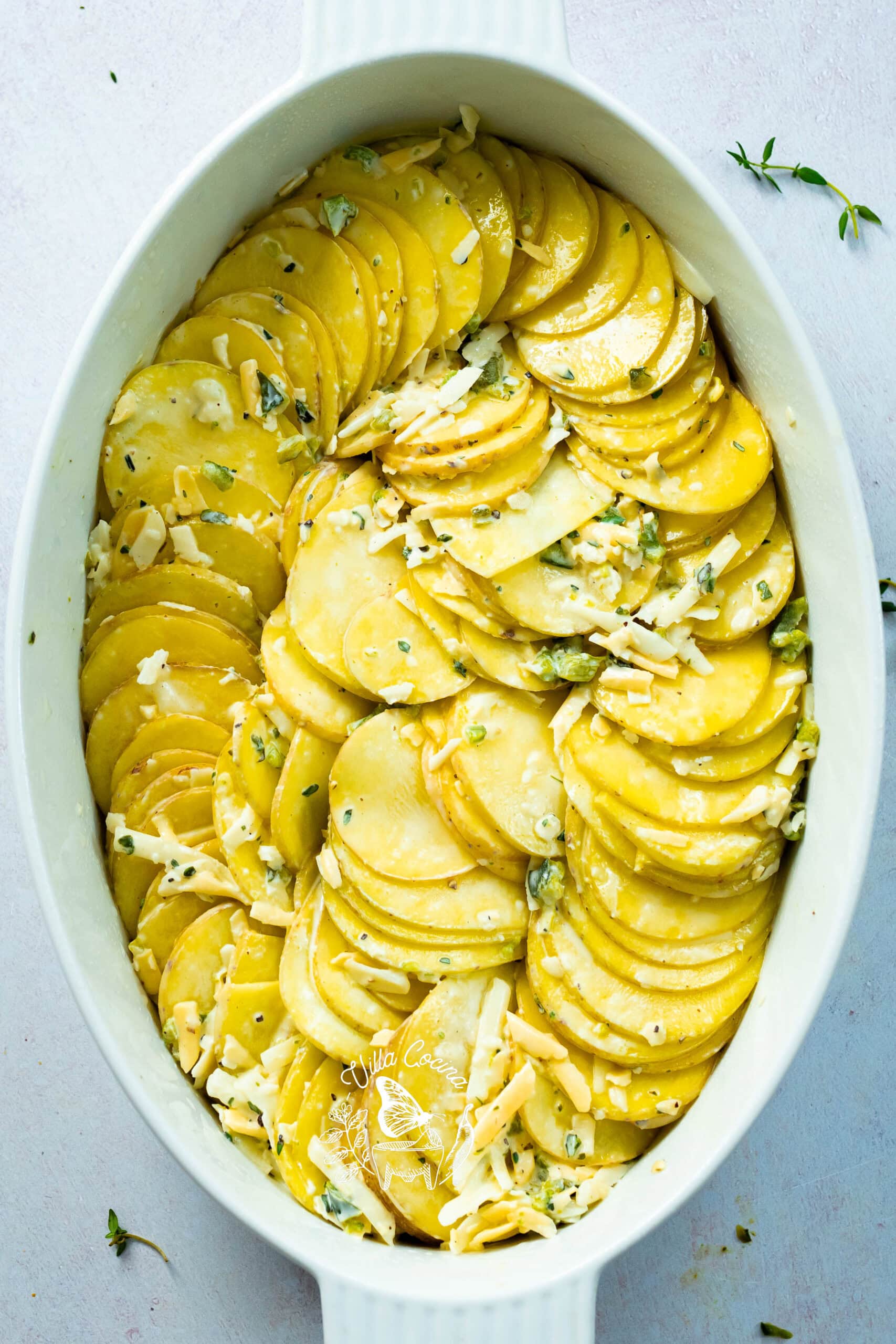 Thinly sliced potatoes stacked and arranged upright in a casserole dish
