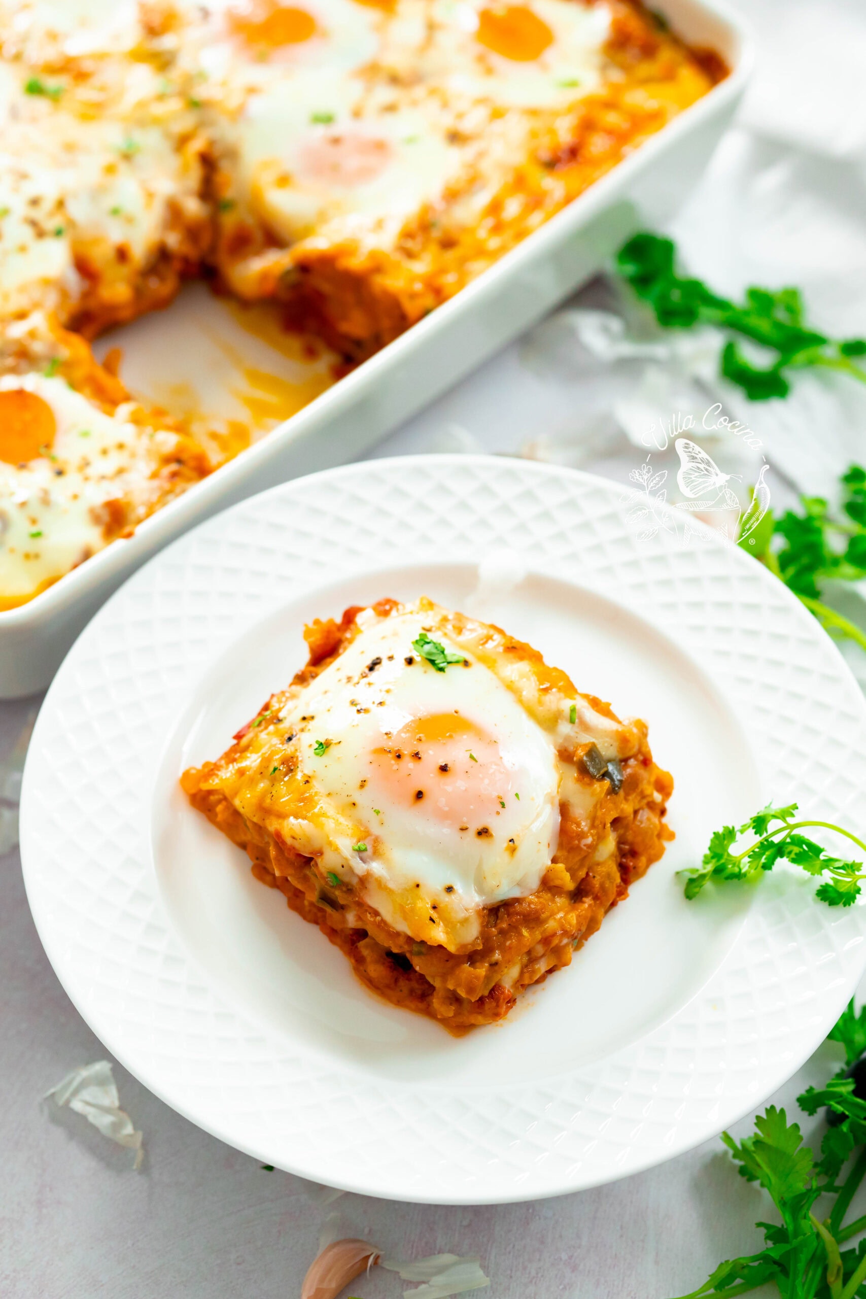 Close-up of a cut slice of huevos rancheros casserole with baked egg.