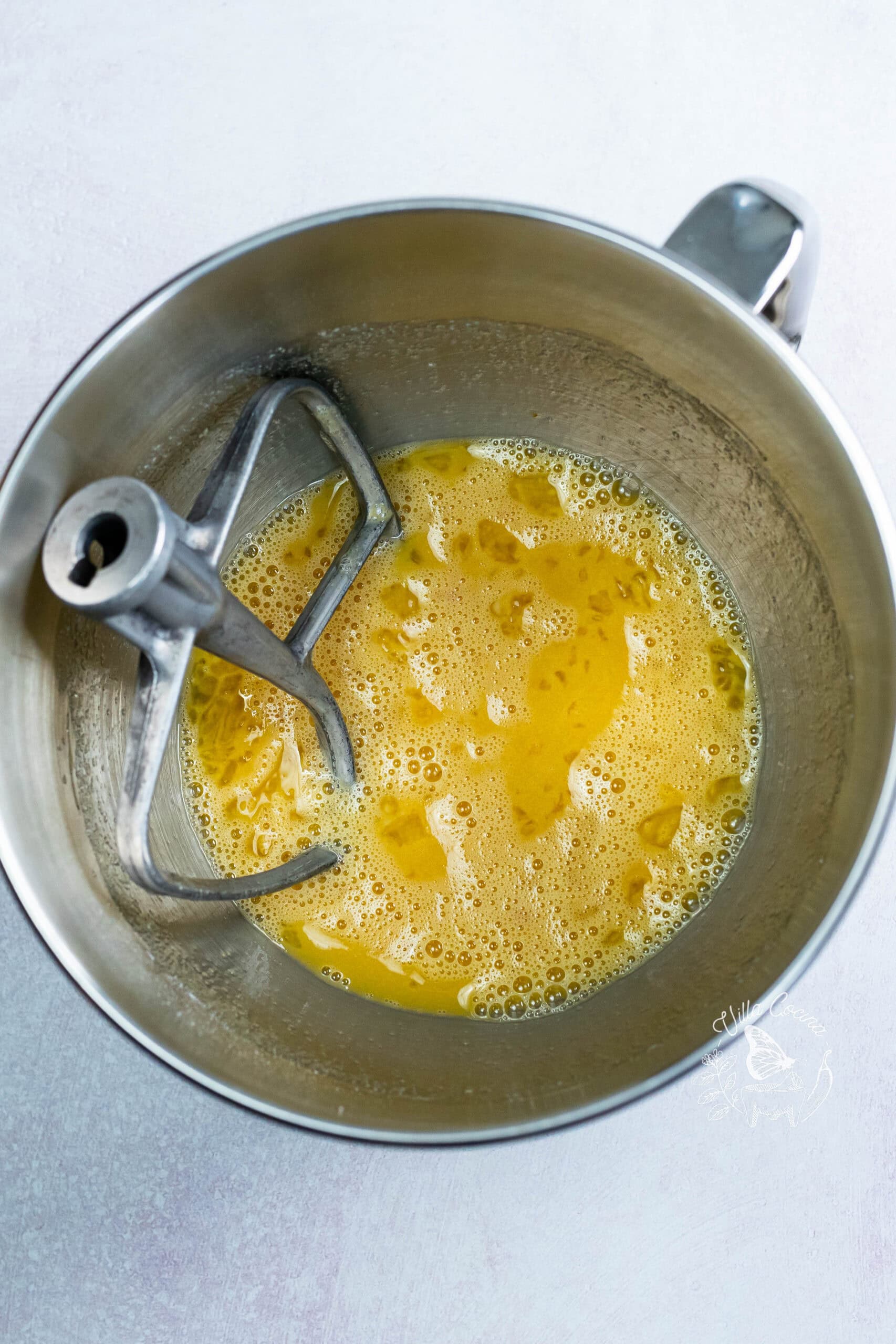 Wet ingredients for concha dough in a mixer bowl with the paddle attachment.