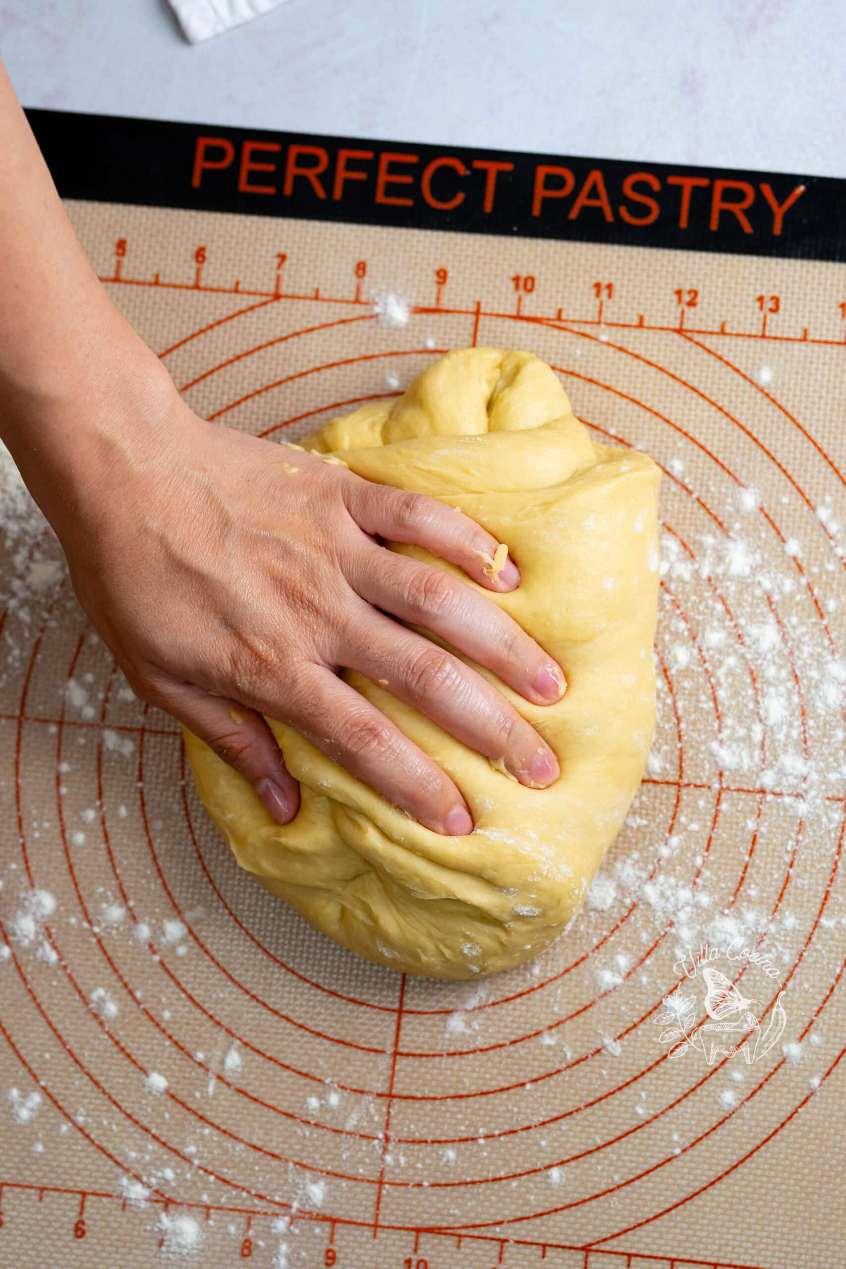 Kneading concha dough by hand on a lightly floured silicone mat.