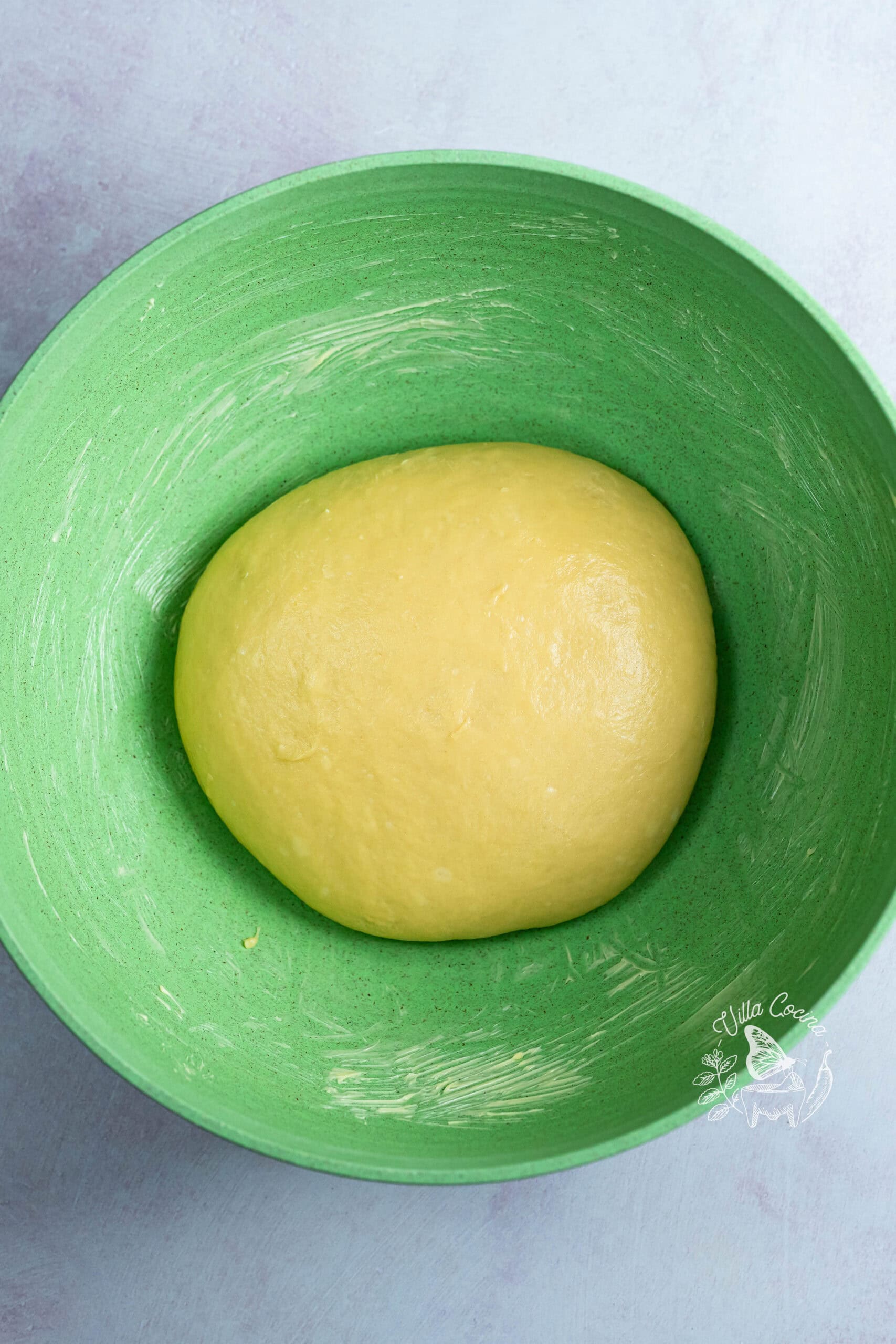 Concha dough in a buttered bowl before rising.