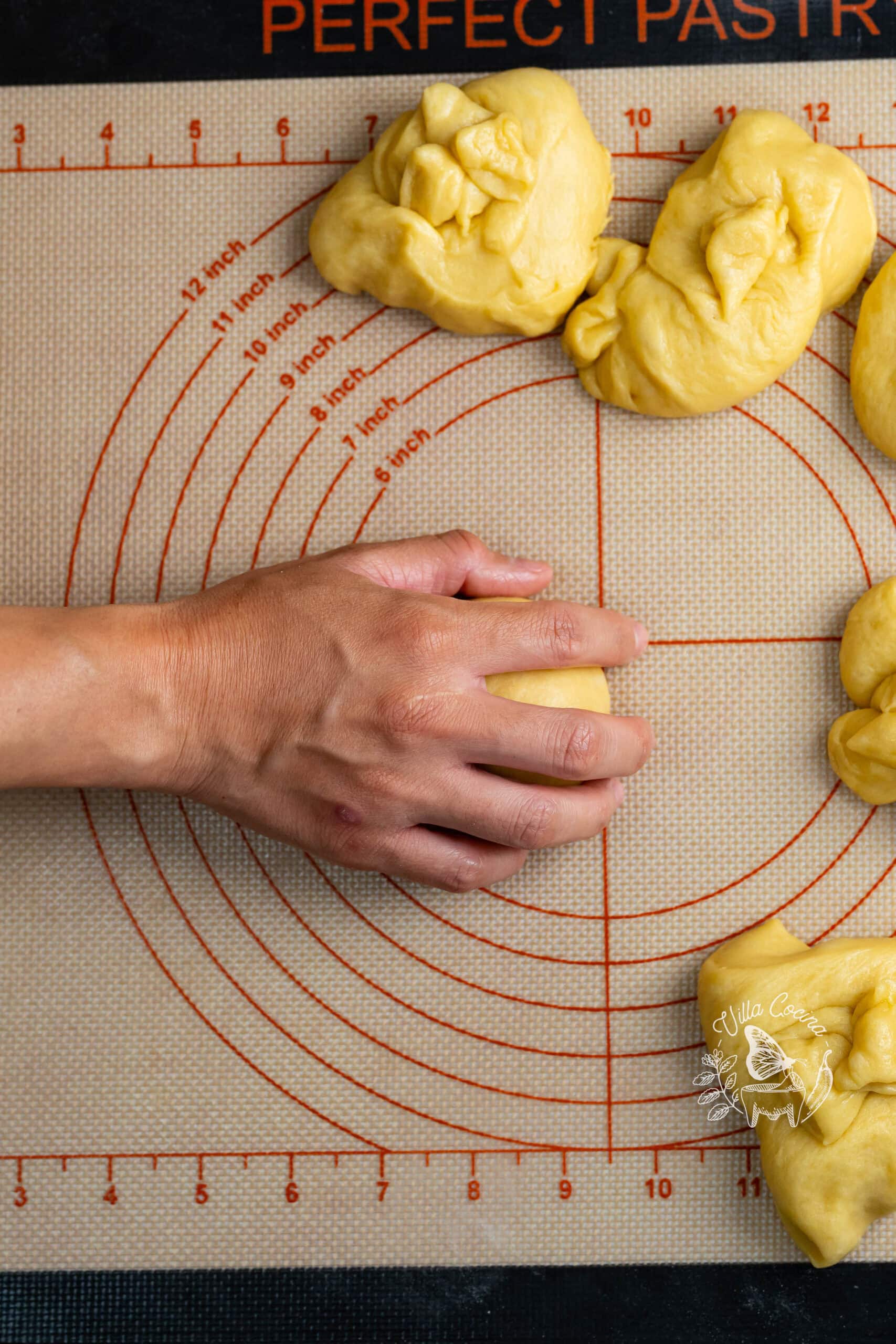 Hand rolling a portion of concha dough into a smooth ball.
