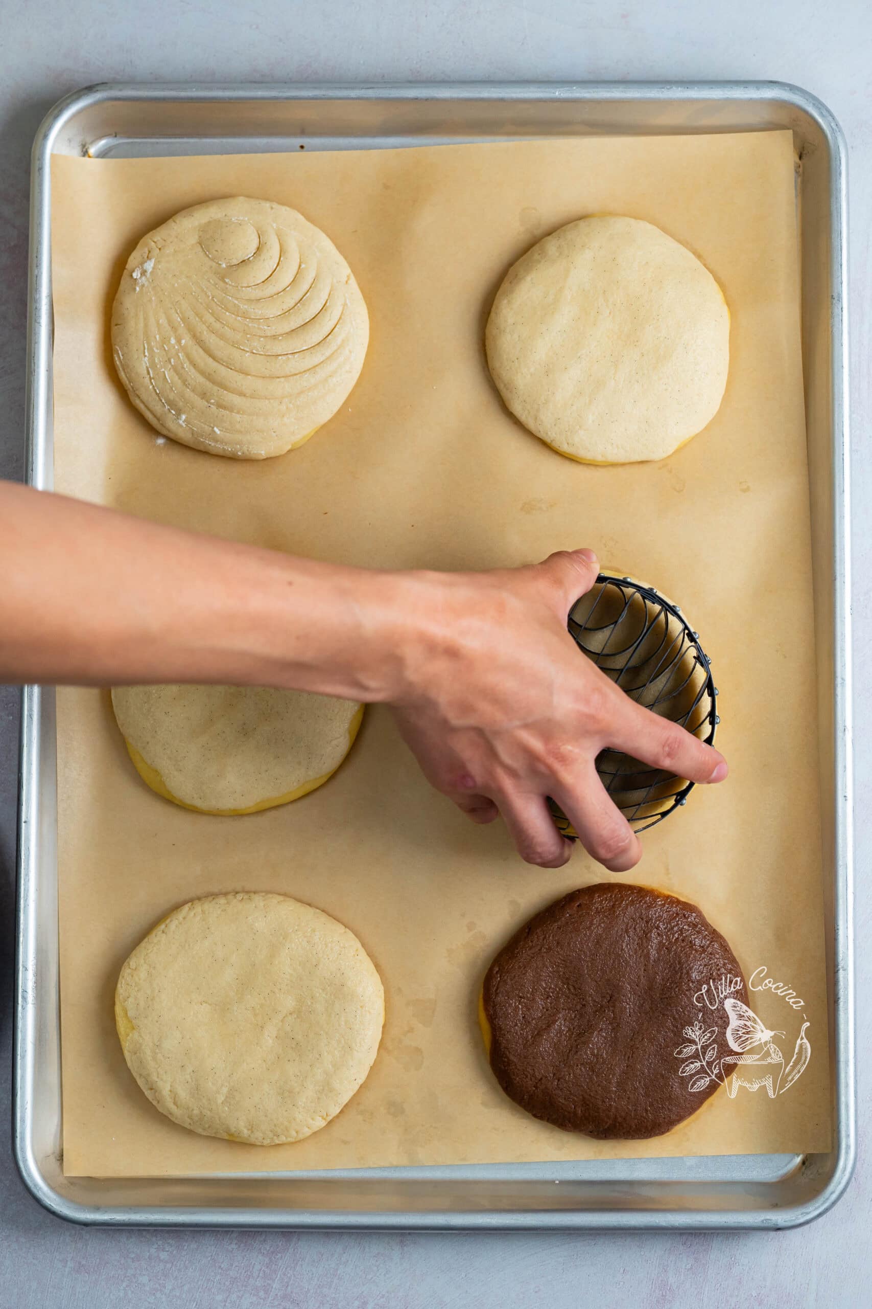 Pressing a concha stamp into vanilla sugar topping.